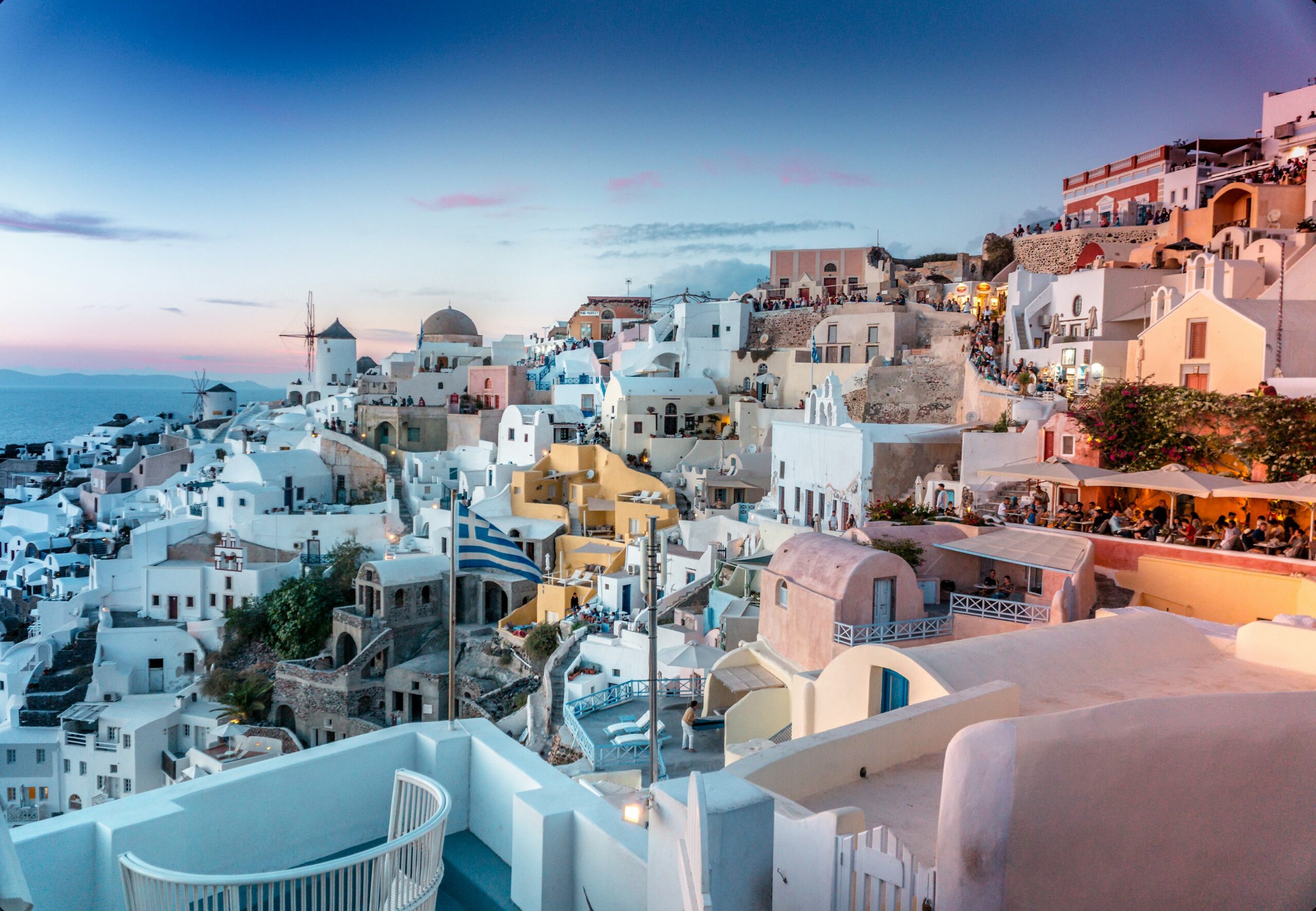 White-washed cliffside houses of Santorini above the caldera at sunset